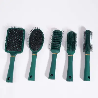 Hair comb held in hand showing the textured anti-slip grip and rounded teeth