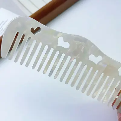 Comb held against a hand showing the ergonomic handle and smooth finish