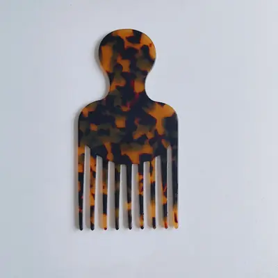 Comb being used to detangle curly hair with gentle pressure