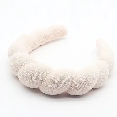 Headband worn on a woman's head during a spa treatment, keeping hair off the face