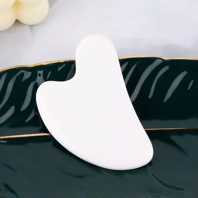 Jade roller being rolled across a hand to demonstrate smooth motion