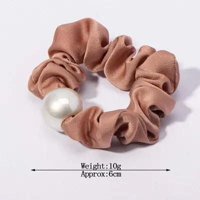 Satin scrunchy with pearl detail wrapped around a section of hair