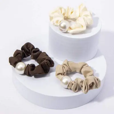Set of large satin scrunchies with pearl accents packed in a custom retail box