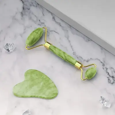 Jade roller and Gua Sha tool in use on a face with serum applied