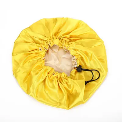 Bonnet with drawstring tied and positioned over a head with curly hair