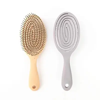 Lollipop hair brush held in hand, showing the ergonomic grip and flexible design