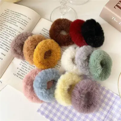 Close-up of the hand-stitched seam on a plush scrunchie with elastic core visible