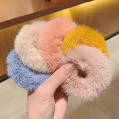 Plush hair scrunchie wrapped around a section of hair, demonstrating the gentle hold