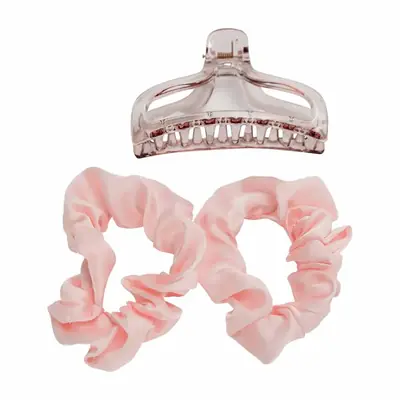Satin heatless curler wrapped in hair showing the claw clip and scrunchie securing the end