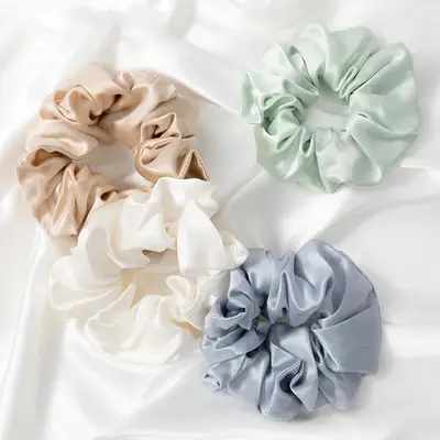Silk scrunchie wrapped around a section of hair, demonstrating the gentle hold