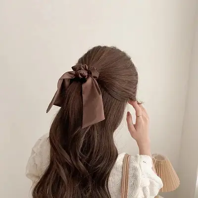 Satin scrunchie wrapped around a ponytail showing the wide, smooth band