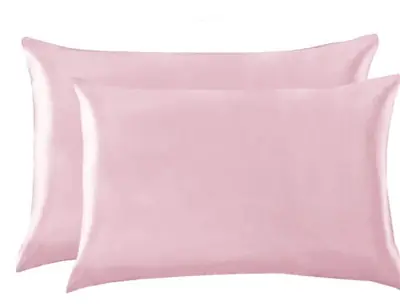Satin pillowcase on a bed with a person sleeping, highlighting the smooth surface