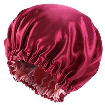 Satin bonnet worn on a head showing the smooth outer layer and soft binding