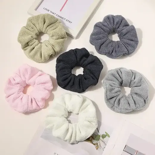 A set of custom microfiber fabric scrunchies laid out flat in different colours