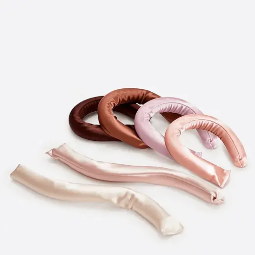 Set of six satin covered heatless hair curler rods laid out flat