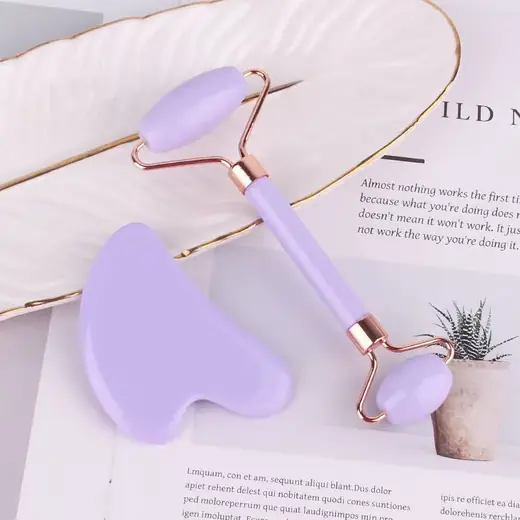 Set of two natural jade tools: Gua Sha scraper and jade roller laid out on a white surface
