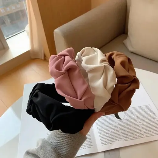 Fabric headband laid flat showing the hand-sewn seam and smooth surface