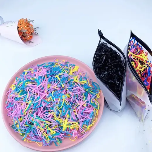 Pack of 500 small disposable hair elastic rubber bands laid out in a row
