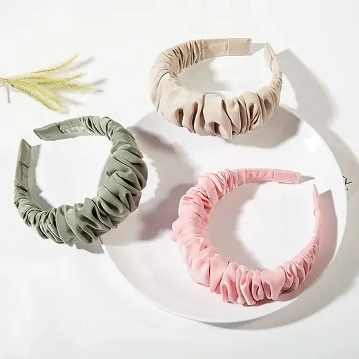 Solid colour headband made from custom fabric, laid flat showing the hand-stitched seam