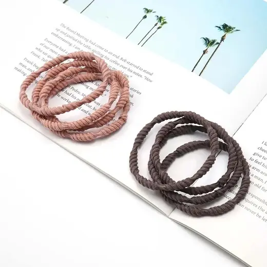 Set of boho-style hair ties in various custom shapes and colours laid out on a white surface