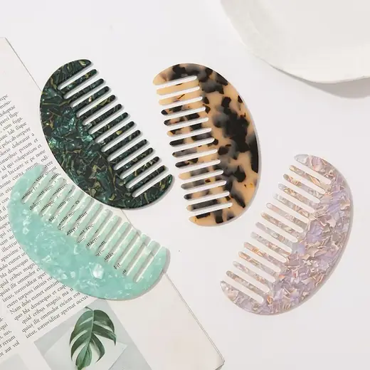 Wide tooth comb with tortoise shell pattern and rounded teeth laid flat