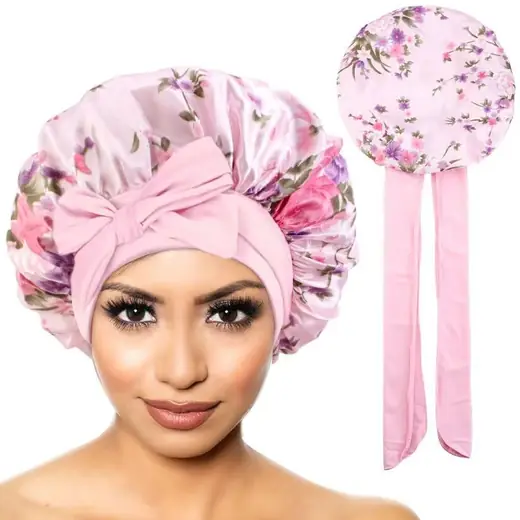 Satin bonnet with floral print laid flat, showing double-layer construction and tie bands