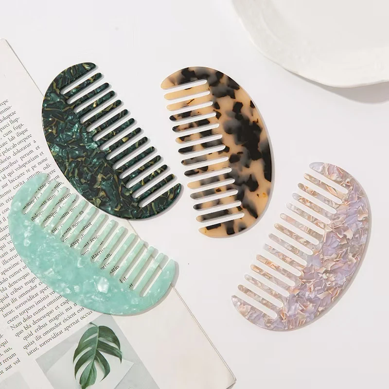 Wide tooth comb with tortoise shell pattern and rounded teeth laid flat