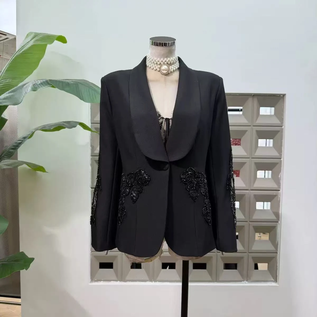 Black shawl collar blazer with black beaded applique at the hip and sleeves