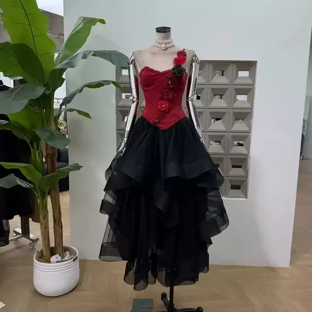 Red corset with three dimensional roses over a layered black tulle midi skirt
