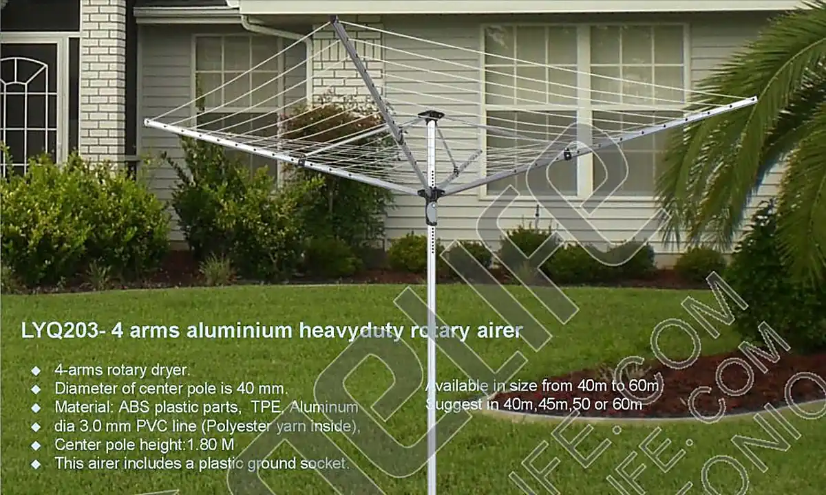 Four-arm aluminium rotary airer set up on a lawn outside a house