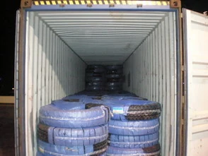 Truck tyres loaded and stacked inside an export container