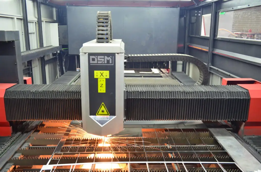 Laser cutting machine cutting stainless steel keyboard panels in the KEYU workshop