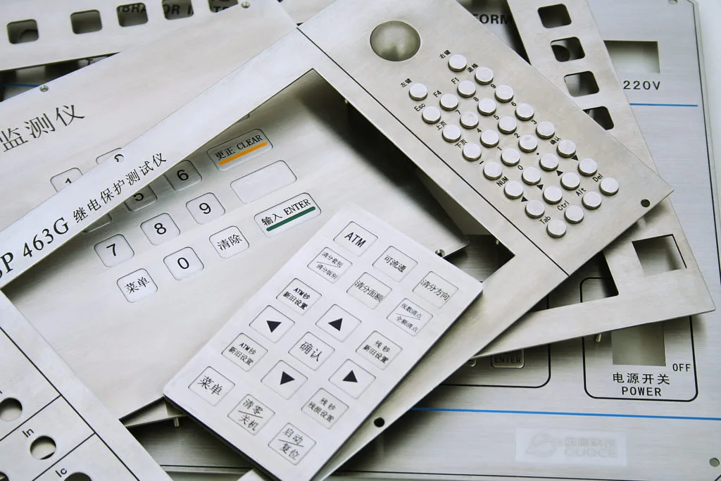 Stack of custom stainless steel and membrane keypad panels produced by KEYU