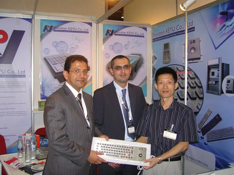 KEYU staff presenting a stainless steel industrial keyboard to visitors