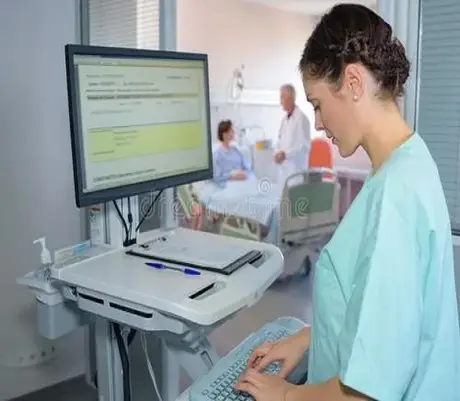 Clinician entering data at a hospital workstation keyboard