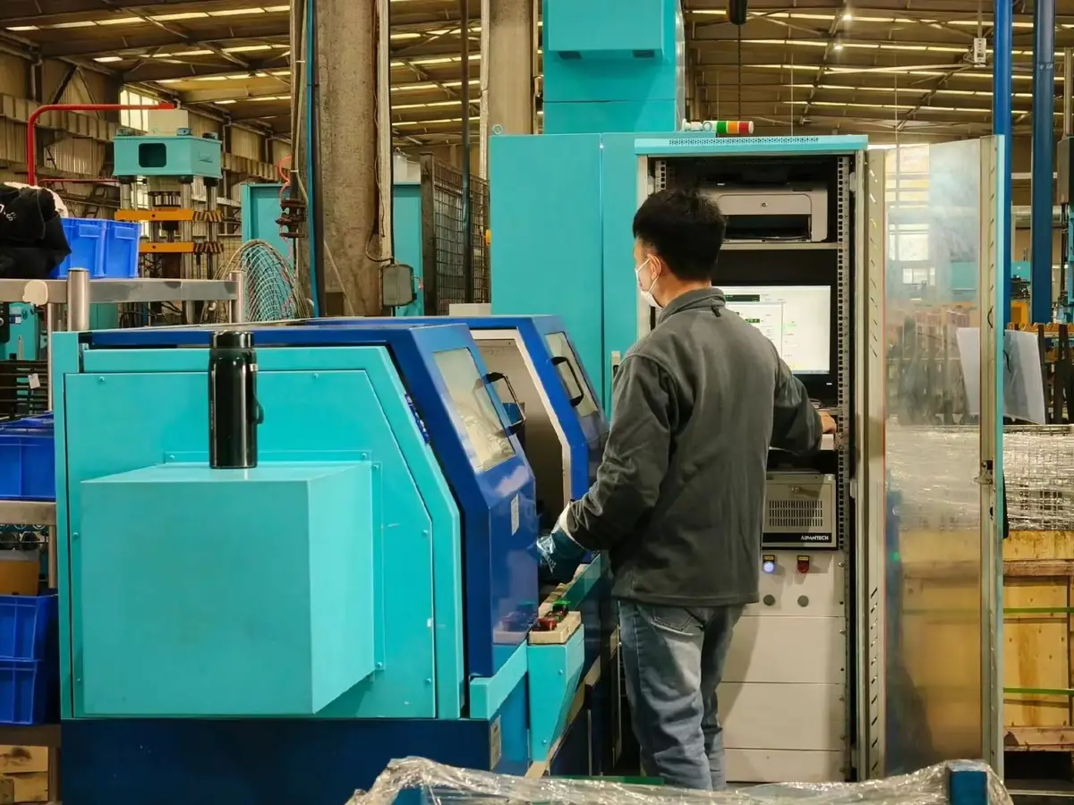 Machinist operating a production machine on a shaft component