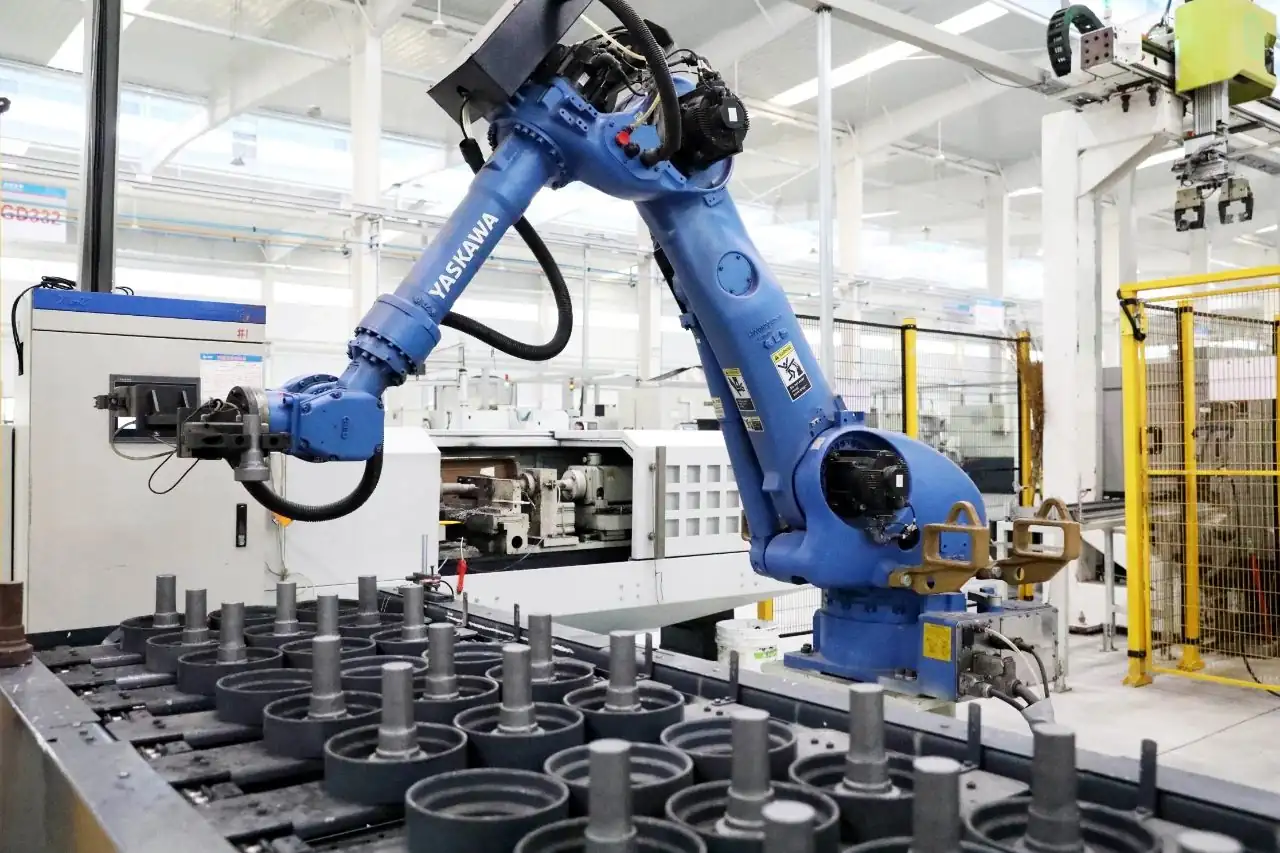 Industrial robot loading machined shaft components onto a fixture