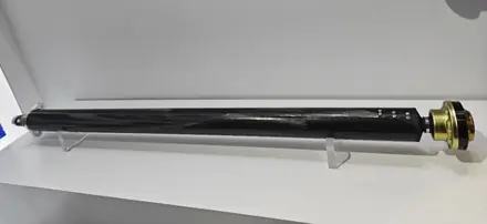 Carbon finished propeller shaft photographed against a white background
