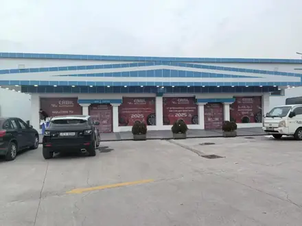 Exhibition hall entrance with vehicles parked outside during the show