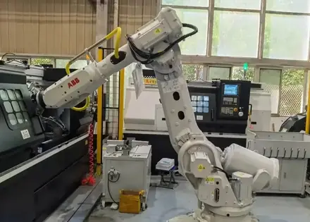 Robot arm serving a machining centre in the production cell