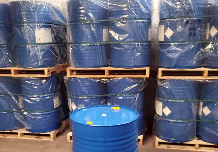 Blue steel drums of epoxy hardener stacked on pallets in a storage area