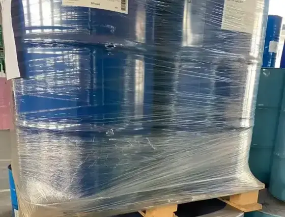 Pallets of shrink wrapped blue drums of epoxy resin in a warehouse