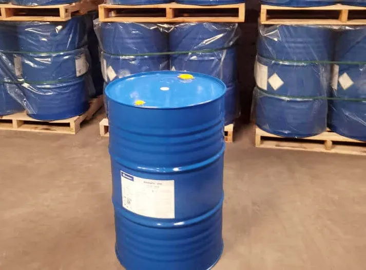 Blue drums of adhesive raw material on pallets in a supply warehouse