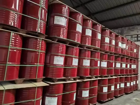 Rows of red isocyanate drums stacked several high in a bonded warehouse