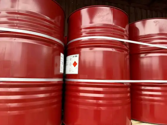 Close view of sealed red steel drums of TDI trimer curing agent with hazard label