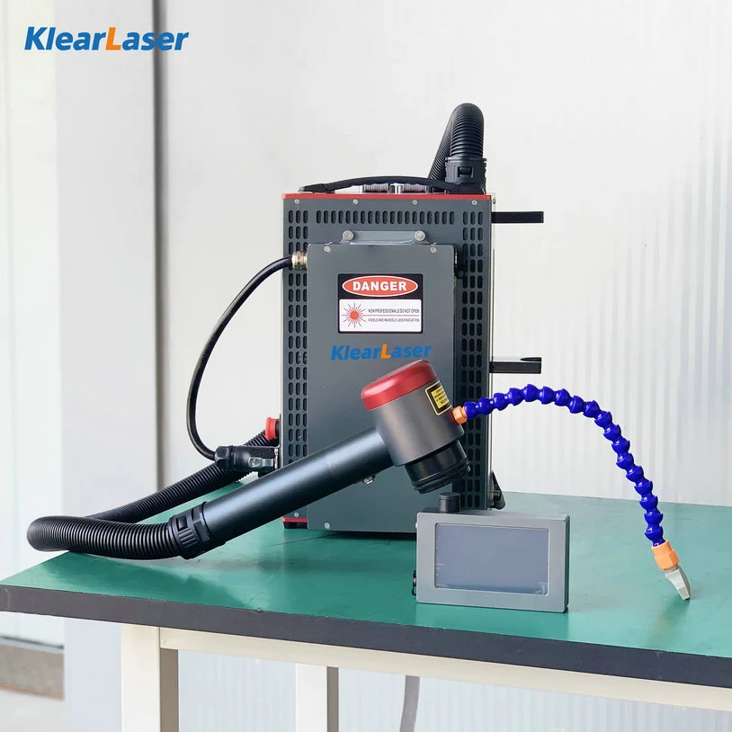 Backpack laser cleaner on a bench with the cleaning head and fibre cable