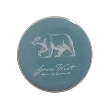 Round tin badge with an embossed polar bear on a pale blue background