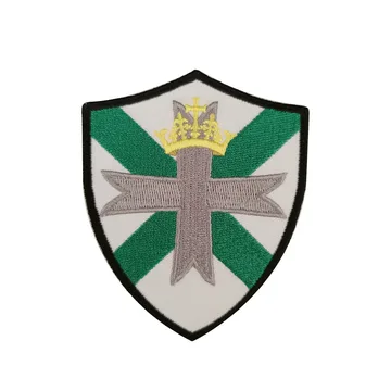 Green and white embroidered shield patch with a crown motif