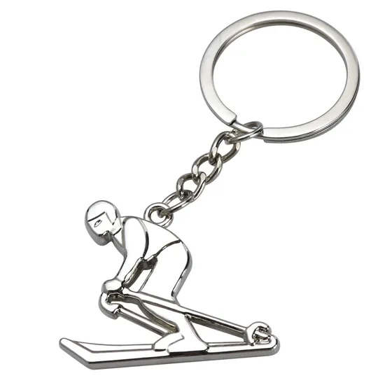 Silver metal skier charm keychain on a split ring, white background