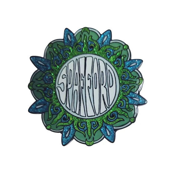 Soft enamel pin with a green leaf border and raised metal lettering